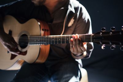 image of a male playing acoustic guitar